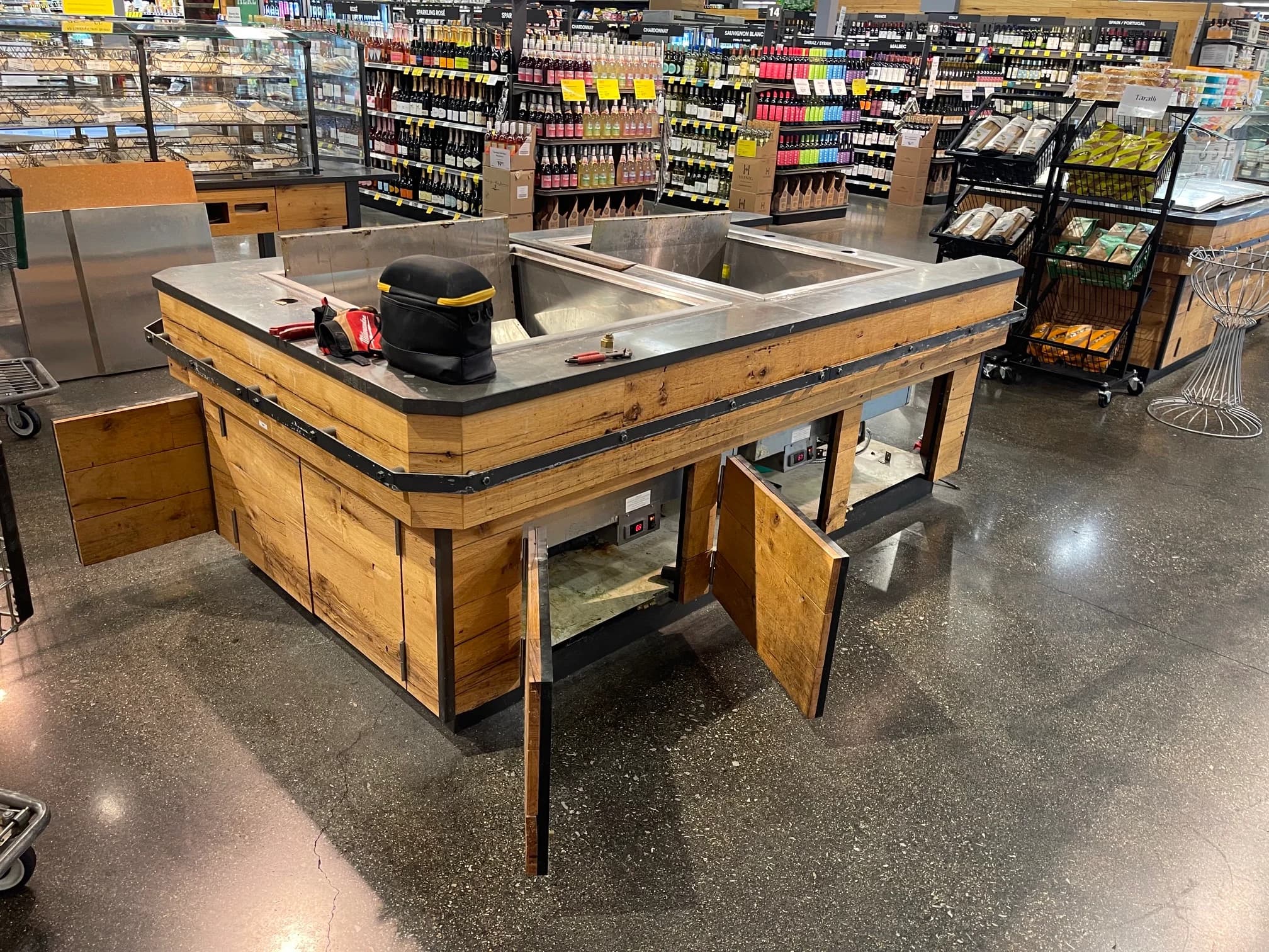 A refrigerated grocery display island opened up during installation