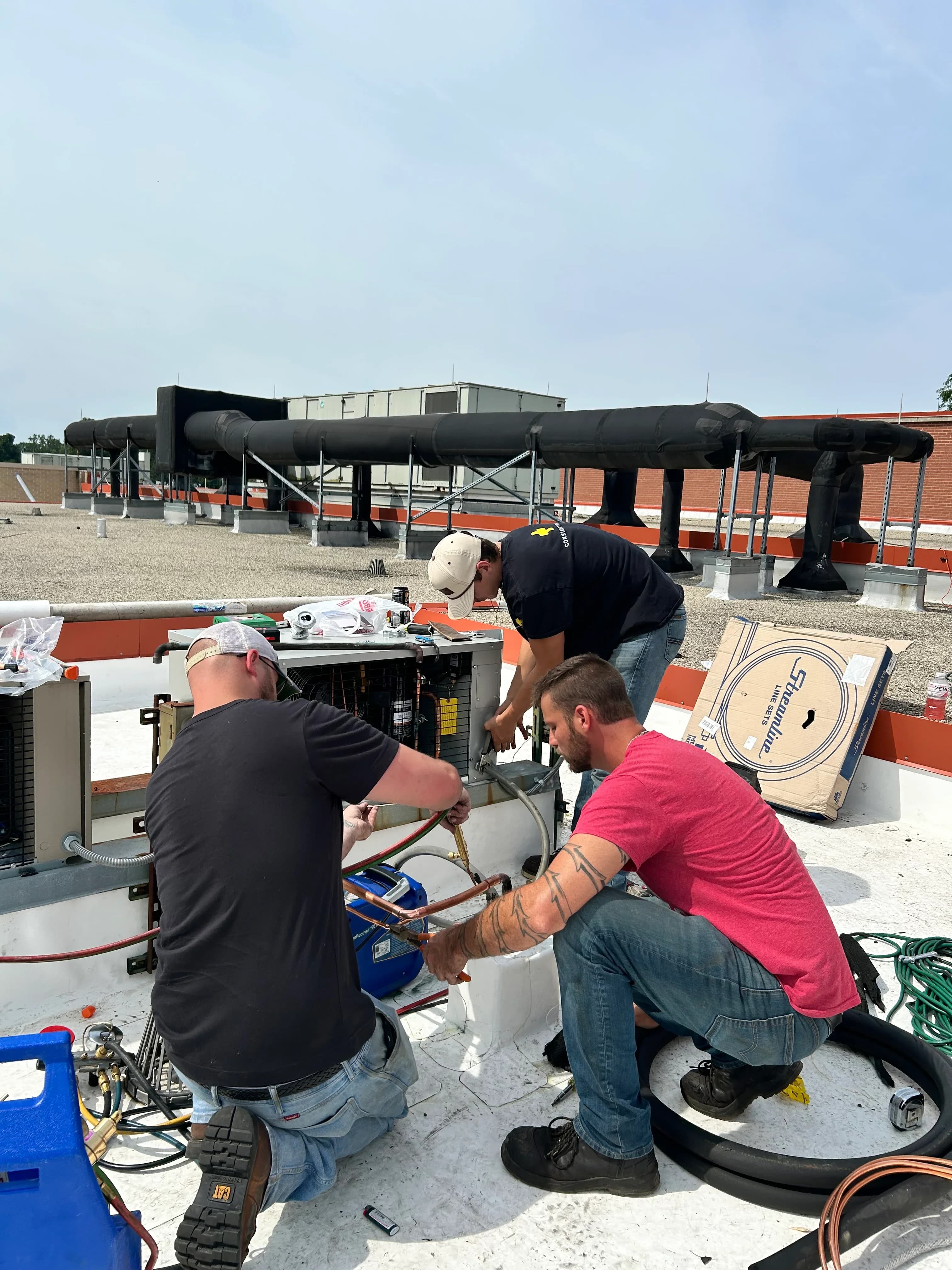 Kitchen & Climate Specialists technicians working together on a rooftop unit