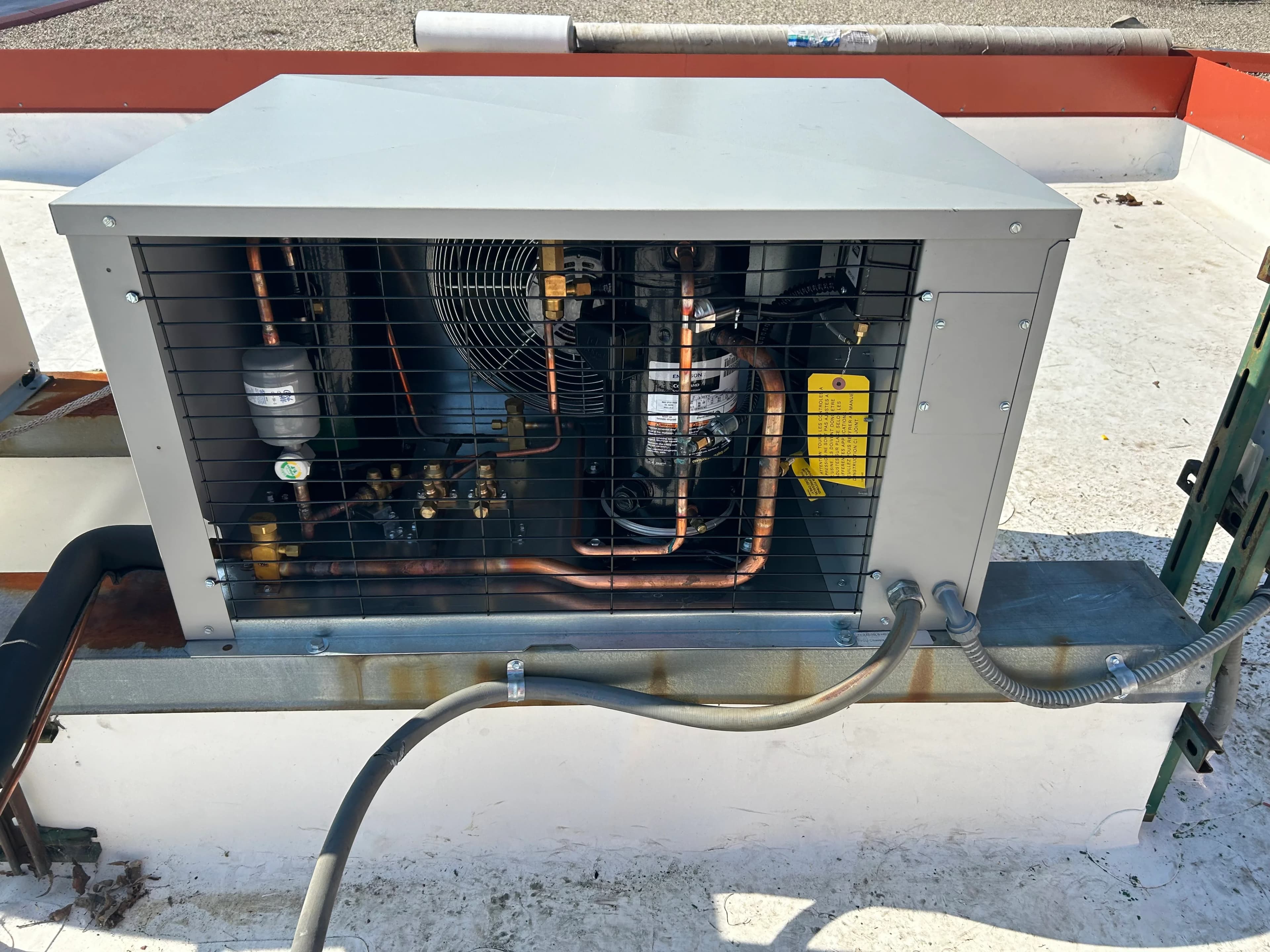 A well-maintained refrigeration condensing unit with the guard open