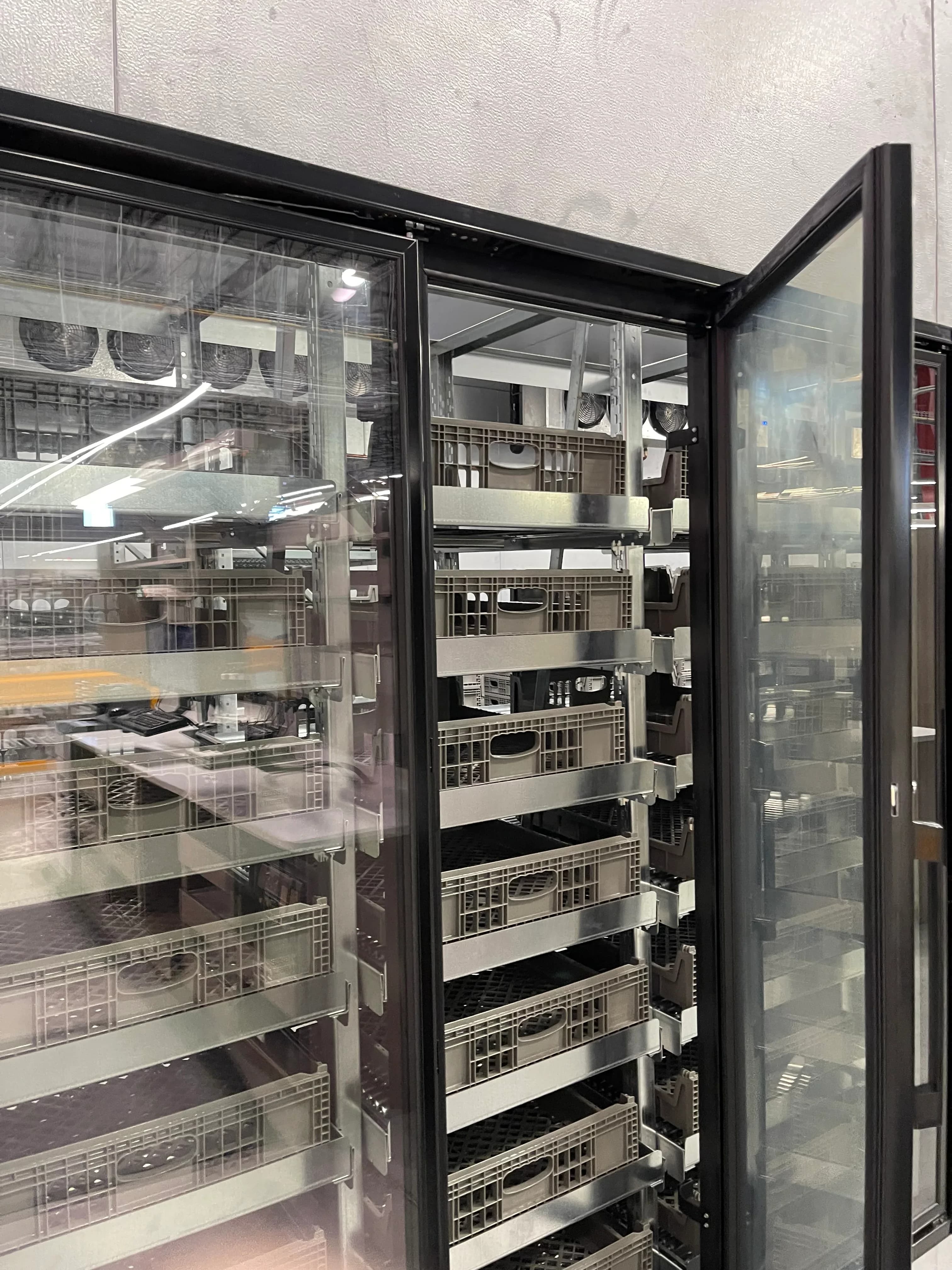 Open glass-door refrigeration racks being serviced