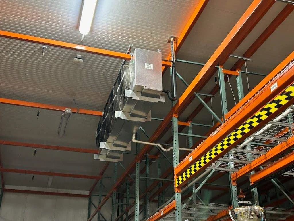 An overhead refrigeration unit above warehouse racking